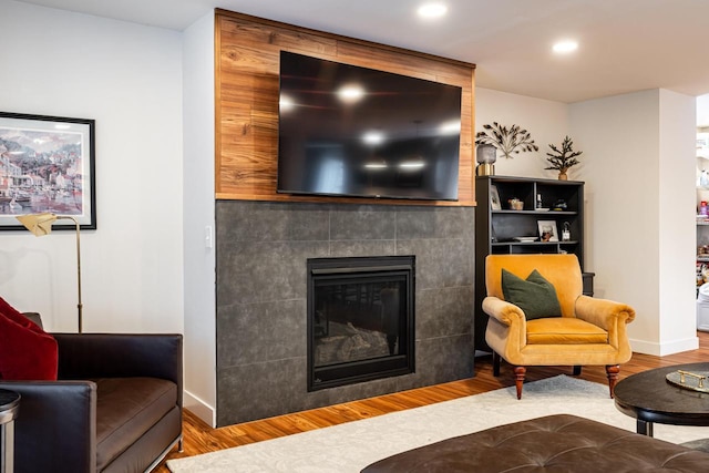 living room featuring hardwood / wood-style floors and a tiled fireplace