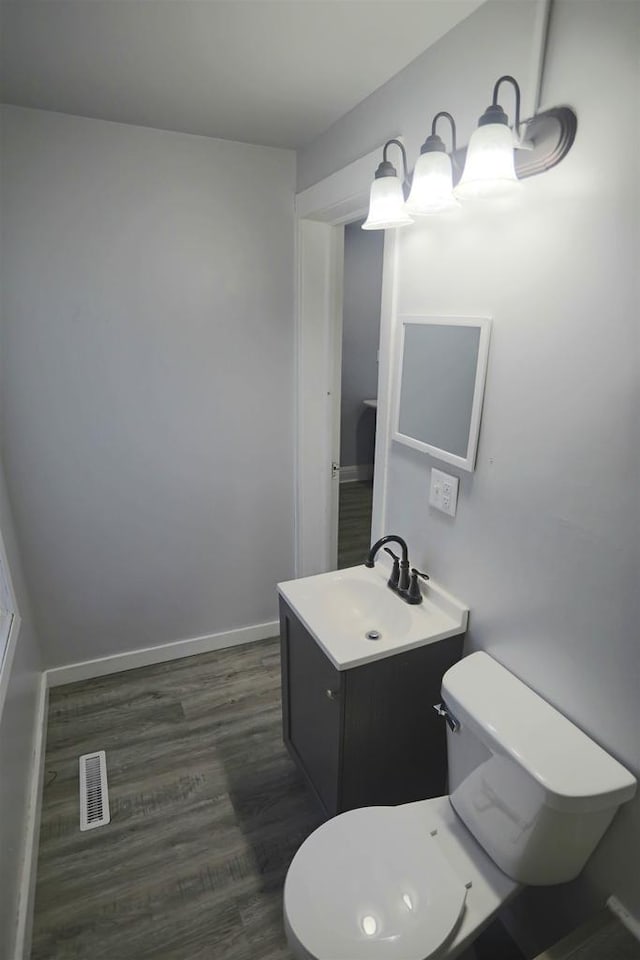 bathroom featuring hardwood / wood-style flooring, toilet, and vanity