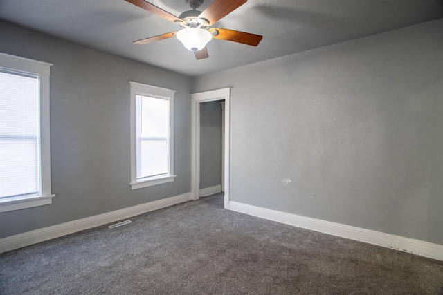 unfurnished room featuring ceiling fan and dark carpet