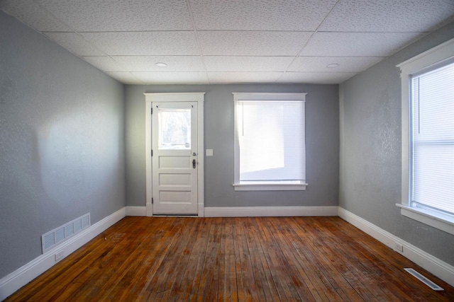 entrance foyer featuring dark hardwood / wood-style flooring and a drop ceiling