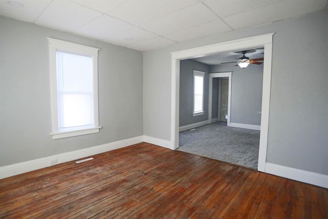 unfurnished room with dark hardwood / wood-style floors and a paneled ceiling