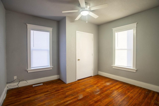 unfurnished bedroom featuring ceiling fan, dark wood-type flooring, and a closet