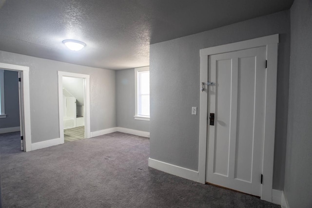 carpeted spare room with a textured ceiling