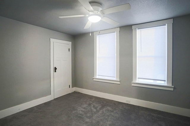 carpeted spare room featuring ceiling fan