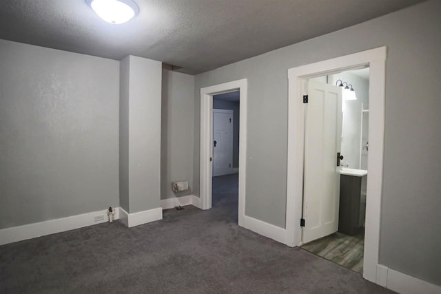 interior space featuring a textured ceiling and dark carpet