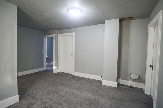 basement with dark colored carpet and a textured ceiling