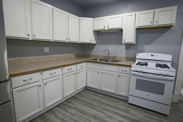 kitchen with dark wood-type flooring, sink, white cabinetry, and white gas stove