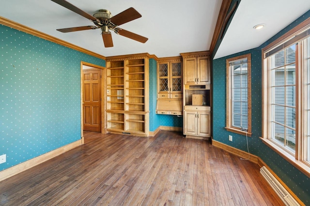 unfurnished living room with dark hardwood / wood-style flooring, crown molding, a wealth of natural light, and ceiling fan