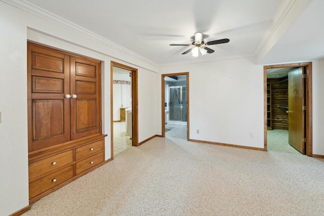 unfurnished bedroom featuring crown molding, ceiling fan, connected bathroom, a walk in closet, and light colored carpet