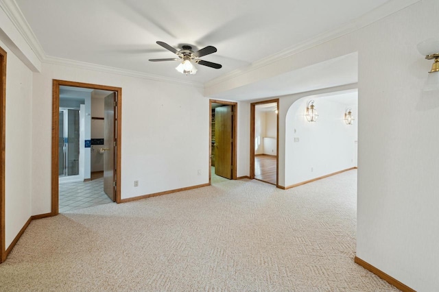 carpeted spare room featuring crown molding and ceiling fan