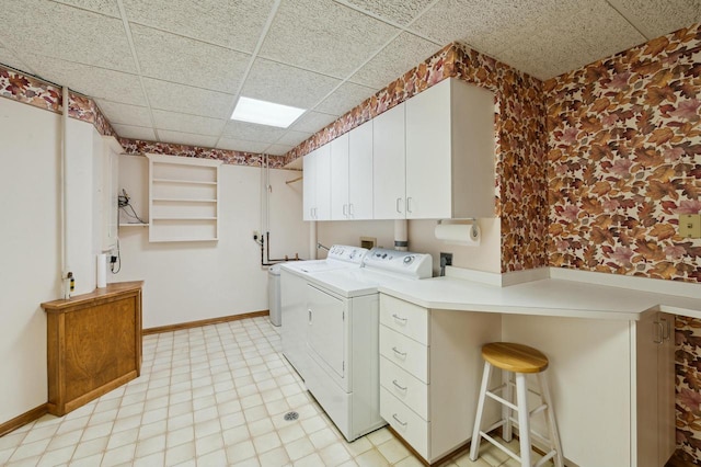 washroom with cabinets and washing machine and clothes dryer