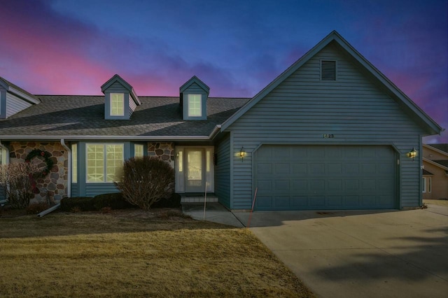 view of front of property featuring a garage and a lawn