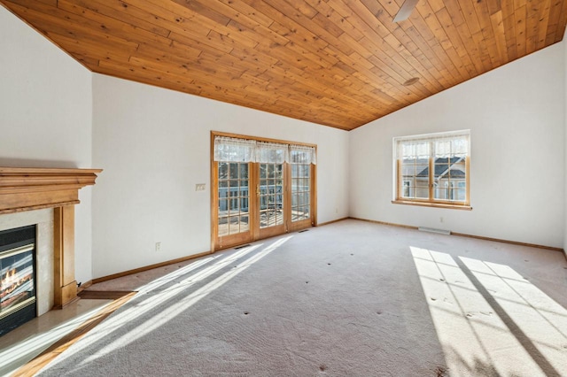 unfurnished living room featuring a high end fireplace, plenty of natural light, light colored carpet, and wooden ceiling