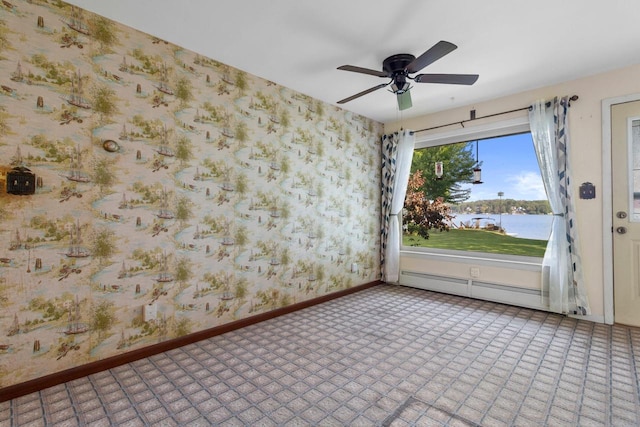 carpeted spare room featuring a baseboard radiator, a water view, and ceiling fan