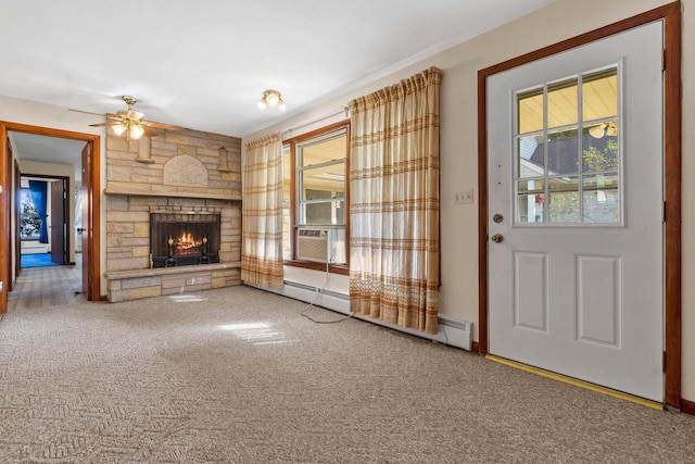 unfurnished living room featuring a baseboard heating unit, ceiling fan, carpet flooring, a stone fireplace, and cooling unit