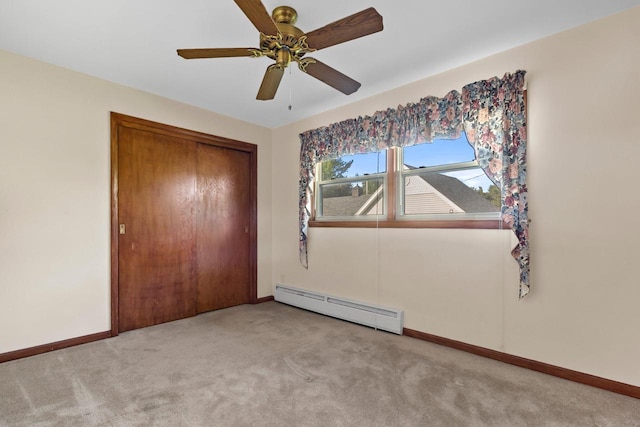 unfurnished bedroom with a closet, ceiling fan, light colored carpet, and baseboard heating