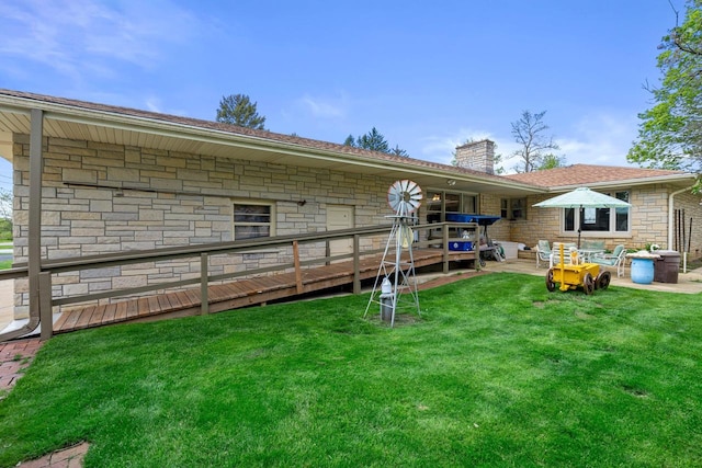 back of property featuring a deck and a lawn