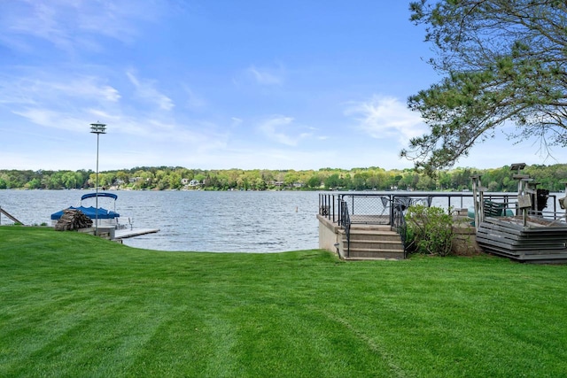 view of dock with a water view and a yard