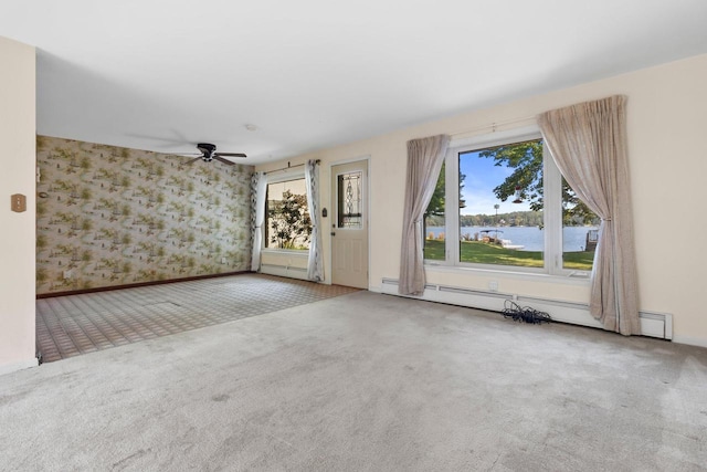 carpeted empty room featuring a baseboard radiator and a water view