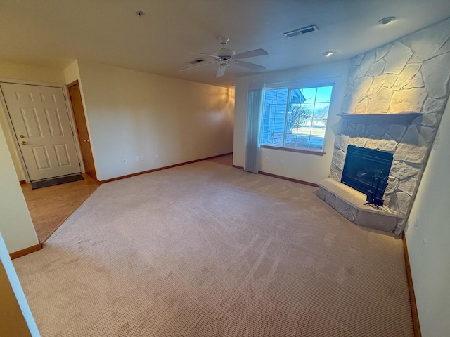 living room with a fireplace, light colored carpet, and ceiling fan