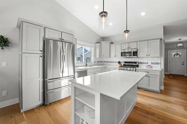 kitchen with pendant lighting, sink, a center island, lofted ceiling, and stainless steel appliances