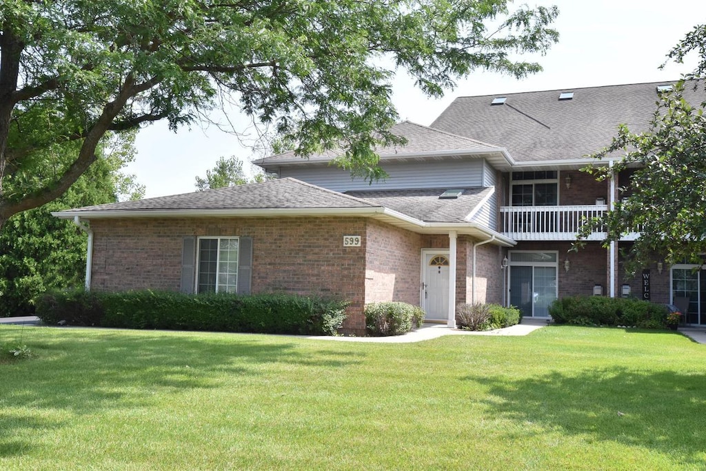 view of front of home featuring a front lawn and a balcony