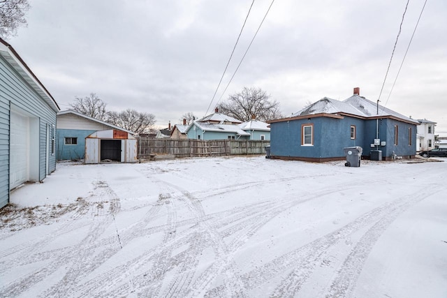 yard covered in snow with a storage shed