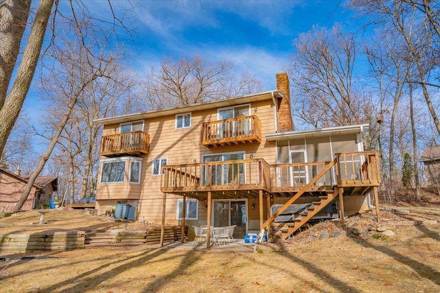 rear view of property featuring a sunroom and a patio area