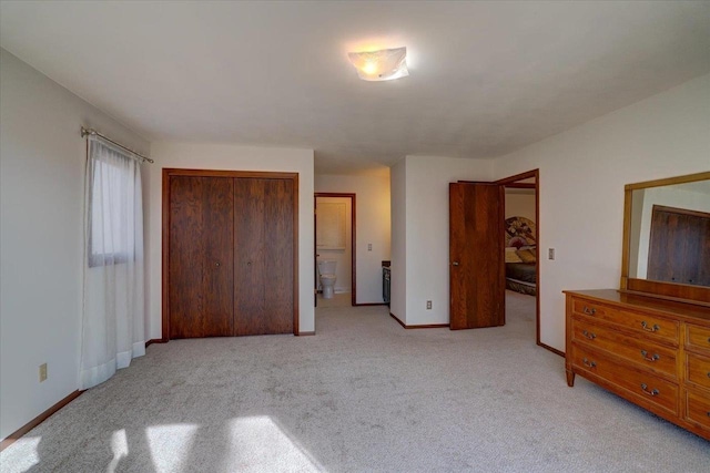 unfurnished bedroom featuring light carpet and a closet