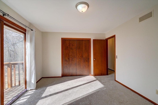 unfurnished bedroom featuring light carpet and a closet