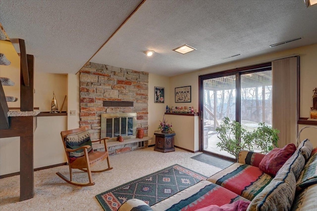 carpeted living room with a textured ceiling and a fireplace