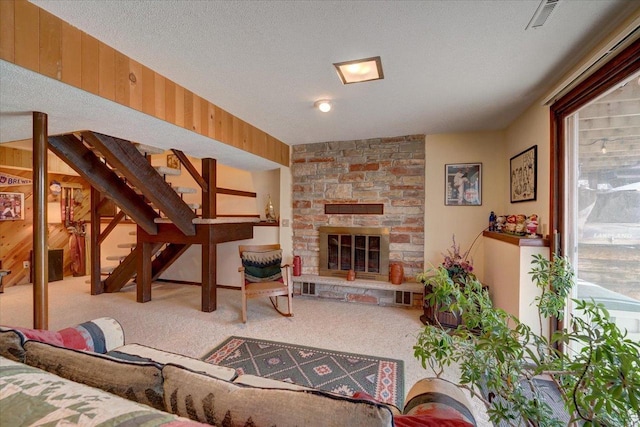 living room with a fireplace, a textured ceiling, light carpet, and wood walls