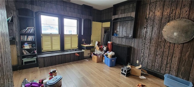 interior space with wood walls and light hardwood / wood-style flooring