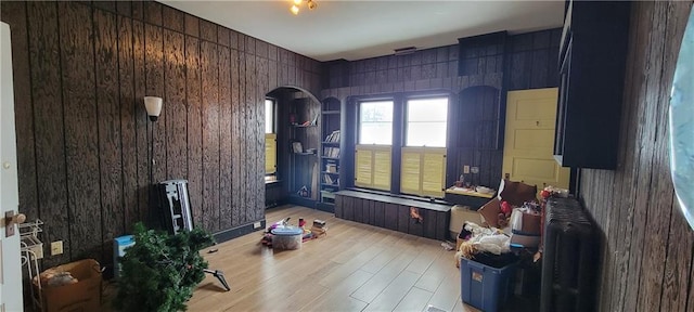 miscellaneous room featuring wood walls and light hardwood / wood-style flooring