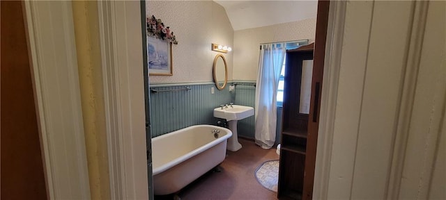 bathroom featuring a bathing tub and lofted ceiling