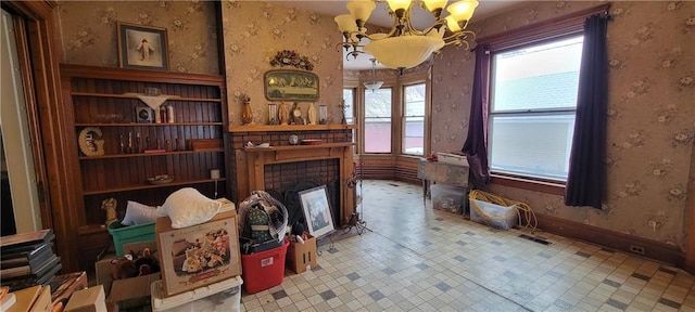 living room with a tiled fireplace and a notable chandelier