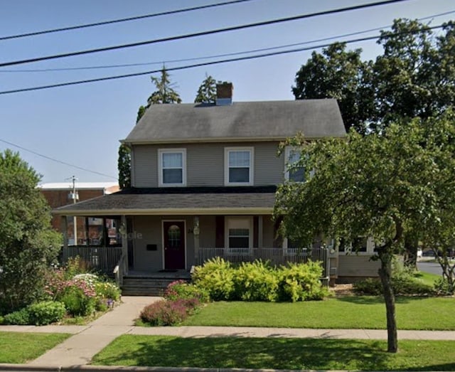 view of front of property with covered porch and a front lawn