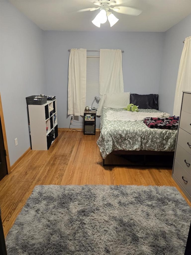 bedroom with light hardwood / wood-style floors and ceiling fan