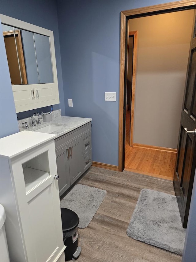 bathroom featuring hardwood / wood-style flooring, toilet, and vanity