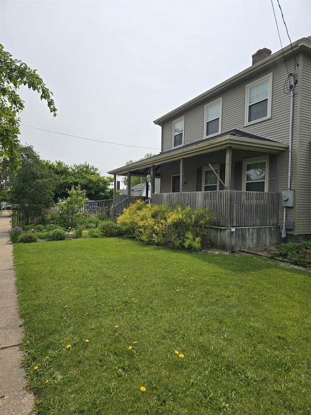 242 W Hickory St, Lancaster, WI 53813 - view of side of property with covered porch, a yard, and a chimney