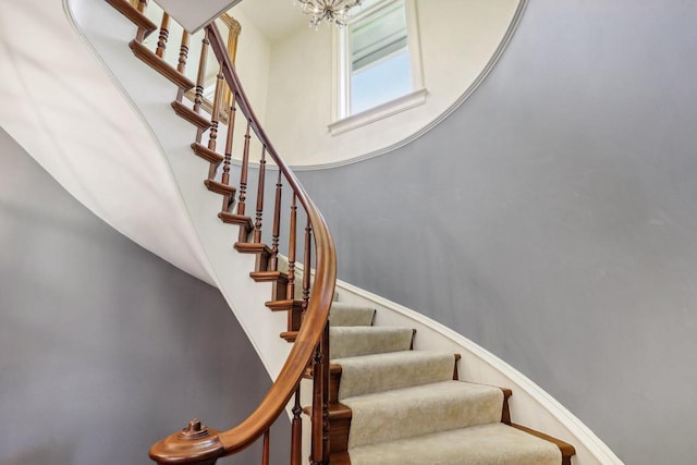 stairs with a chandelier