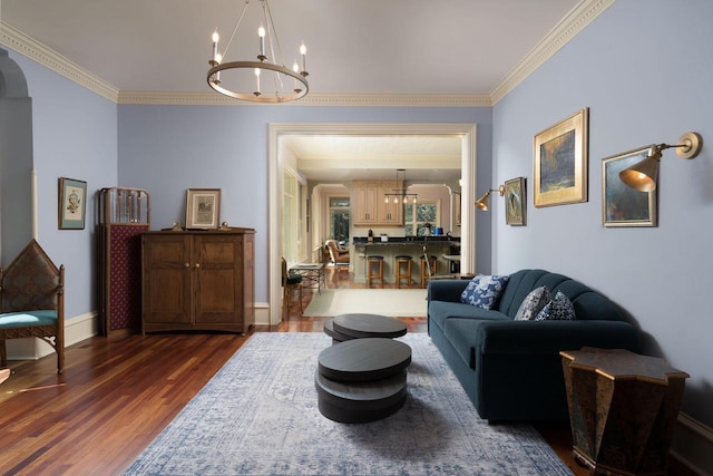 living room with ornamental molding, dark hardwood / wood-style floors, and an inviting chandelier