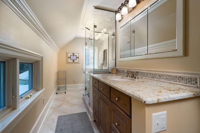 bathroom with tile patterned floors, vanity, ornamental molding, and vaulted ceiling