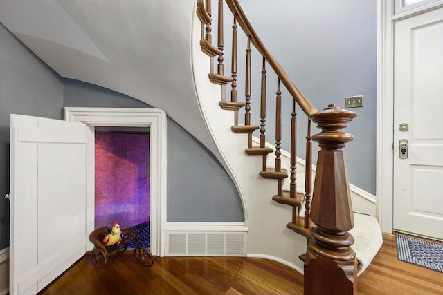 stairs featuring vaulted ceiling and wood-type flooring