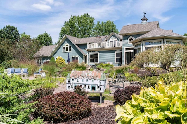 rear view of house featuring a balcony and a patio area