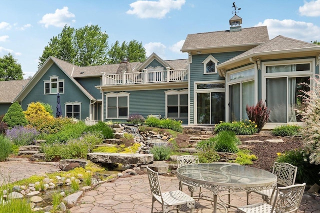 rear view of house with a patio and a balcony