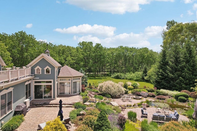 rear view of property featuring a patio area, a sunroom, and a fire pit