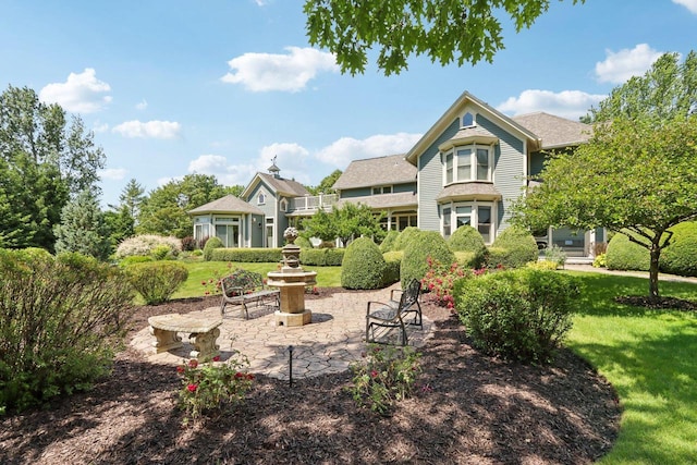 rear view of house with a patio area and a lawn