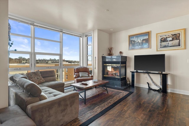 living room featuring dark wood-type flooring and a healthy amount of sunlight