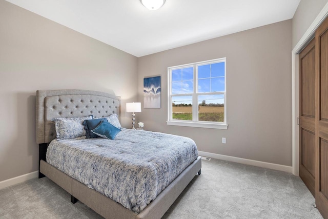 bedroom featuring light colored carpet and a closet